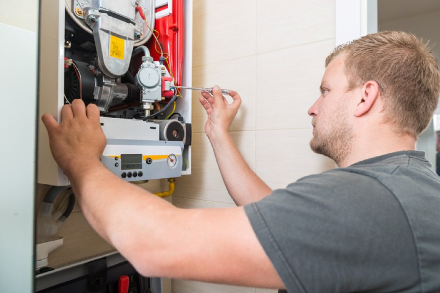 HVAC technician performing furnace maintenance and system inspection