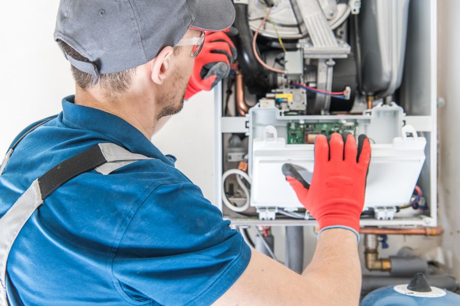 HVAC technician repairing residential furnace control components in McHenry, IL