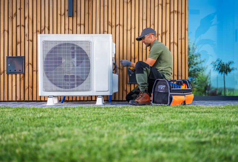 HVAC technician servicing outdoor heat pump unit beside residential home in Woodstock, IL